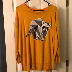 Soft yellow sweater with Aztec raccoon design.